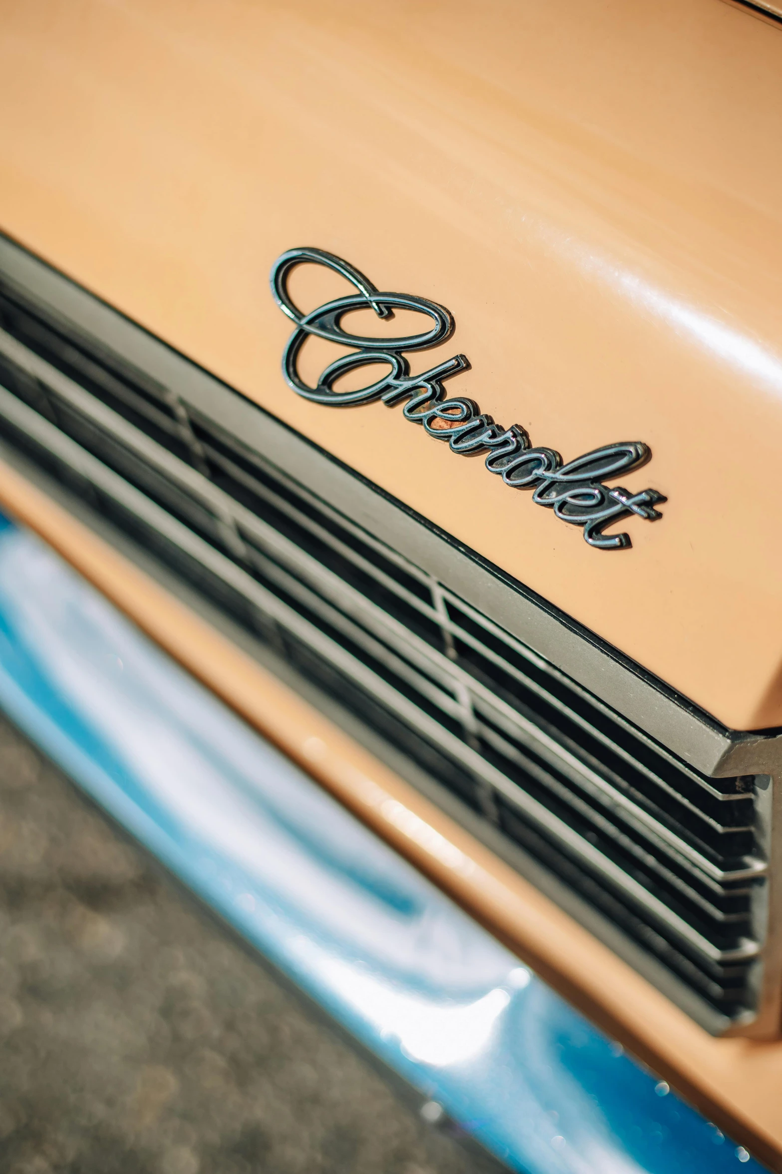 a close up of the front end of a car, an album cover, by Dave Melvin, pexels contest winner, photorealism, brown and cyan color scheme, insanely detailed c 10.0, caramel, emblem