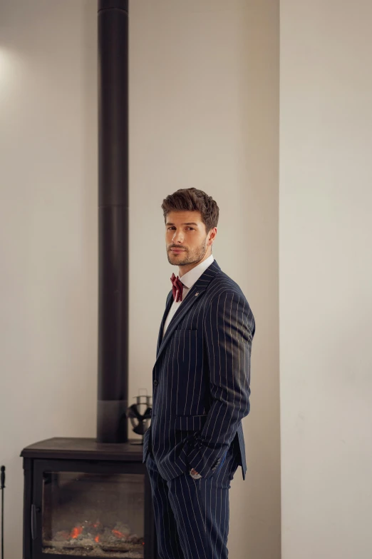 a man in a suit standing in front of a stove, inspired by Ramon Pichot, david gandy, soccer player timo werner, wearing a pinstripe suit, profile image