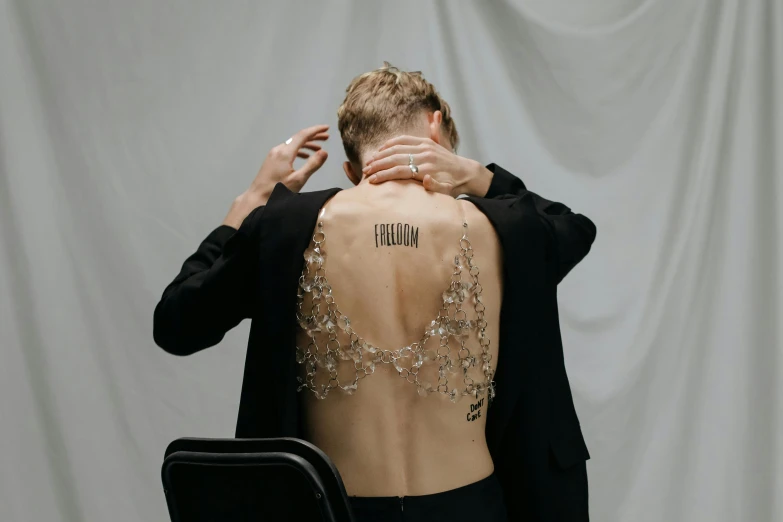 a woman with a tattoo on her back, by Winona Nelson, trending on pexels, delicate androgynous prince, with crystals on the walls, yung lean, his arms are behind his back