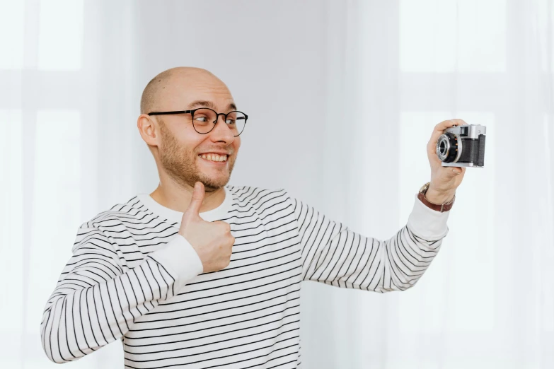 a man taking a picture with a camera, bald man, nerdy appearance, youtube thumbnail, professional modeling
