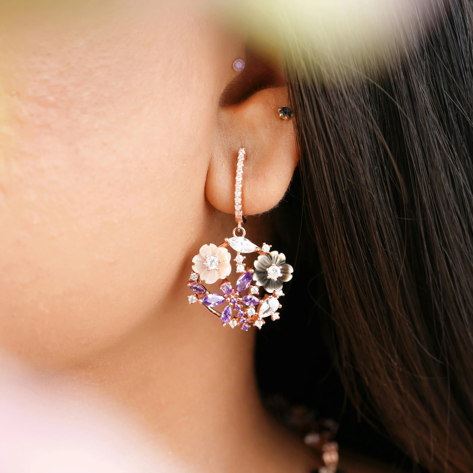 a close up of a person wearing a pair of earrings, trending on pexels, mingei, purple flowers, embedded with gemstones, miniature product photo, thumbnail