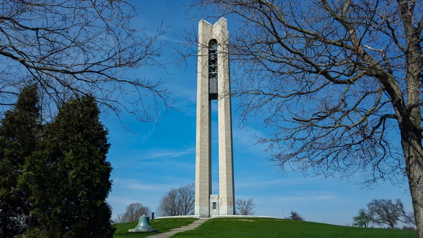 a tall clock tower sitting on top of a lush green hillside, art nouveau, louis kahn, obelisk, photo from 2022, from wheaton illinois