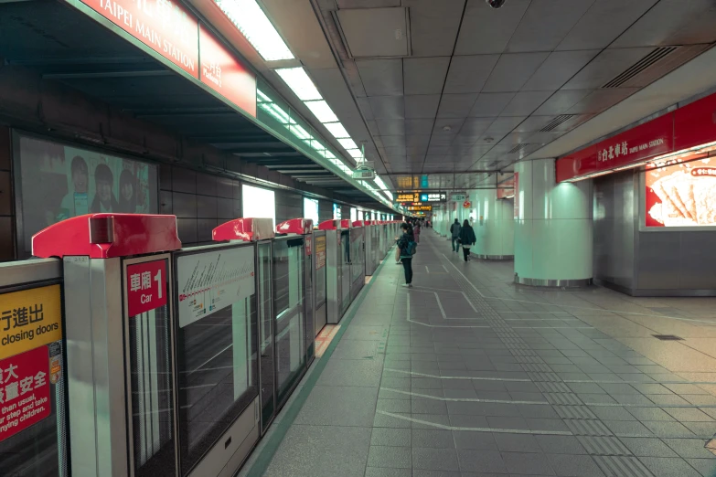 some people walking down an empty, concrete tunnel