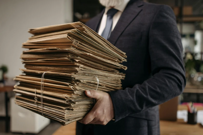 a man in a suit holding a stack of papers, unsplash, brown paper, court archive images, colour photo, cartoons