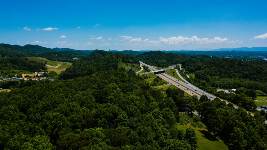 an aerial view of a highway in the mountains, by Dan Frazier, tn, ultrawide angle cinematic view, soaring towers and bridges, 4 0 9 6