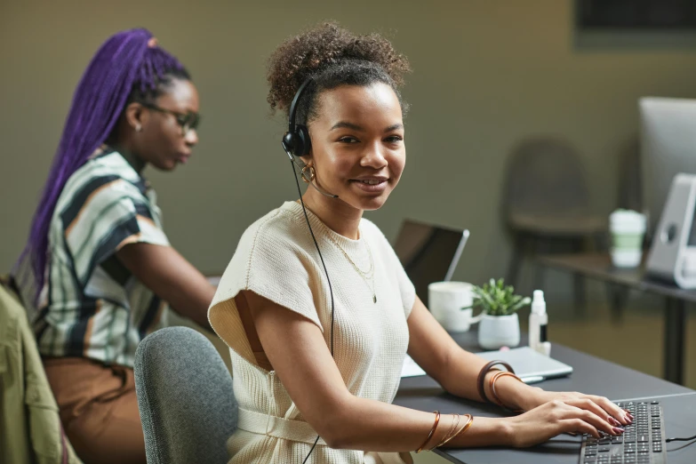 a woman sitting in front of a laptop computer, trending on pexels, wearing headset, black young woman, person in foreground, avatar image