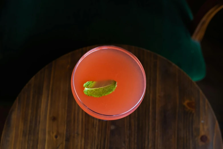 a drink sitting on top of a wooden table, by Austin English, red emerald, top down angle, pink, bar