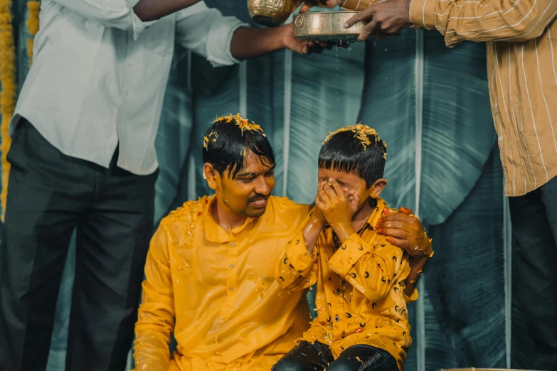 a couple of men sitting next to each other, pexels contest winner, hurufiyya, a boy made out of gold, baptism, taken in 2 0 2 0, jayison devadas