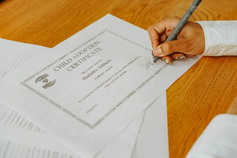 a person writing on paper next to an office chair