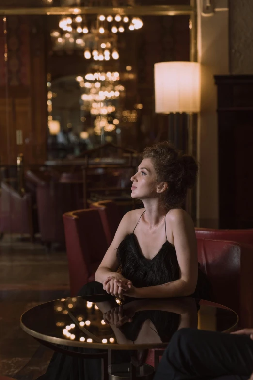 a man and a woman sitting at a table, a portrait, inspired by Nan Goldin, pexels, renaissance, an elegant woman in black dress, sitting in a lounge, posed in profile, angelina stroganova