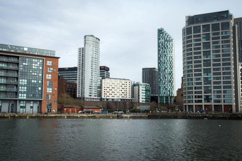 a large body of water surrounded by tall buildings, inspired by Edwin Deakin, unsplash, hurufiyya, manchester, slide show, view from the lake, 2000s photo