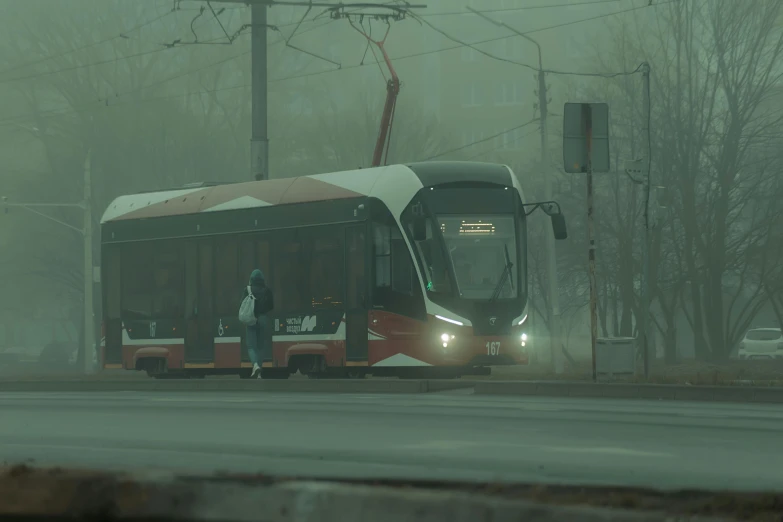 a bus in the fog waiting at a stop light