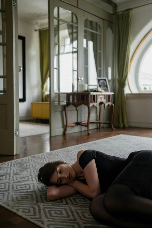 a person laying down on a living room rug