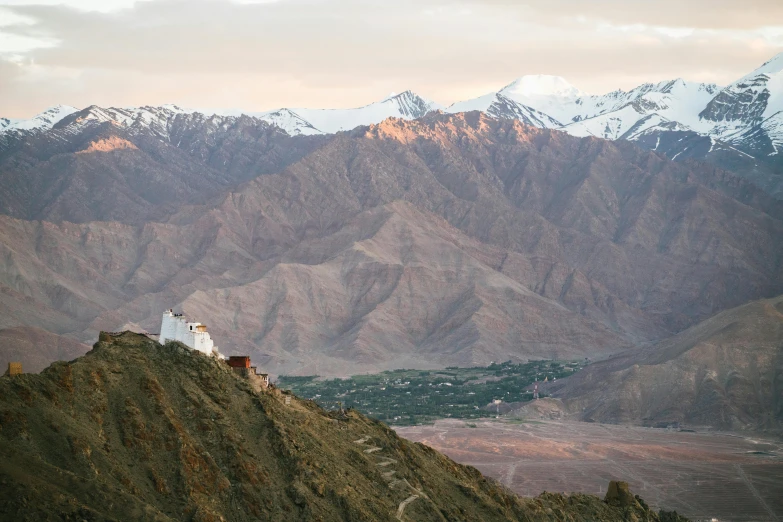 a view of mountains with a church on a mountain top