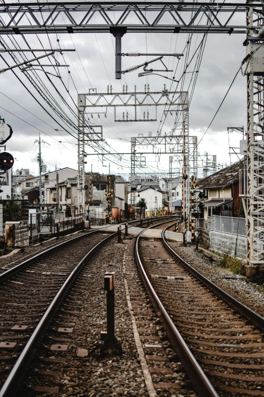 a train traveling down train tracks next to a train station, unsplash, sōsaku hanga, machines and wires everywhere, 2000s photo, 🚿🗝📝, panoramic shot