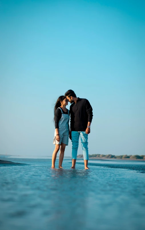 there is a man and woman standing in the ocean