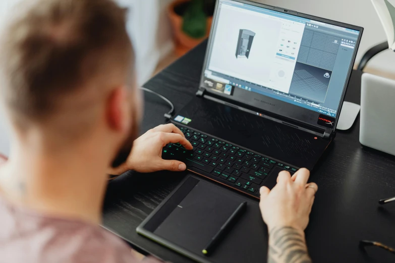 a man sitting at a desk using a laptop computer, a computer rendering, pexels contest winner, skin on the gaming pc, solidworks, bottom angle, inked digital