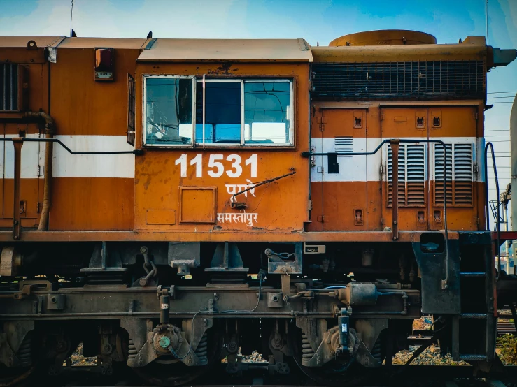 a close up of a train on a train track, pexels contest winner, hyperrealism, hindu aesthetic, orange and white, diesel engine, 🚿🗝📝
