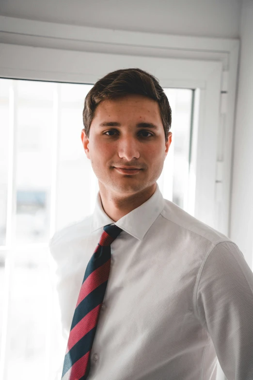 a young man wearing a white dress shirt and red tie