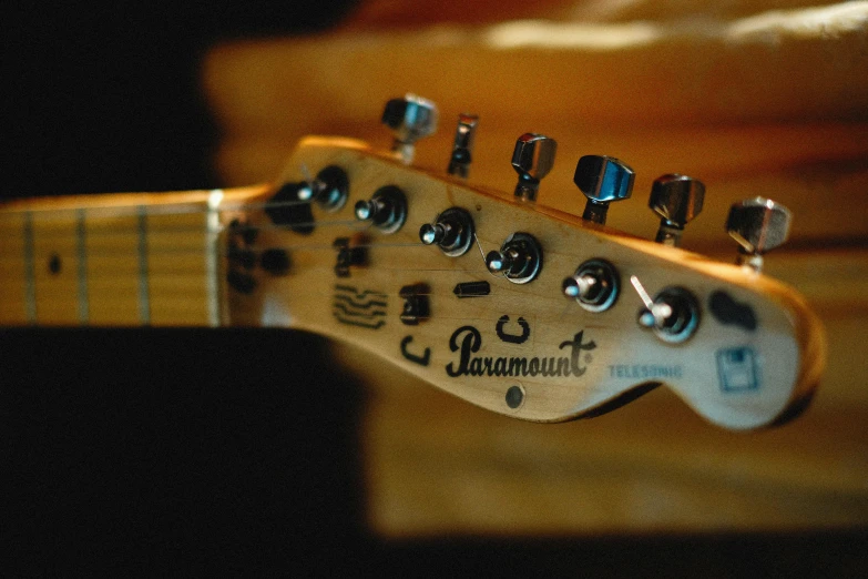 a close up of a guitar neck with a guitar case in the background, by Ryan Pancoast, pexels, baroque, “diamonds, the panorama, cinestill 800t 50mm eastmancolor, taken in the late 2000s