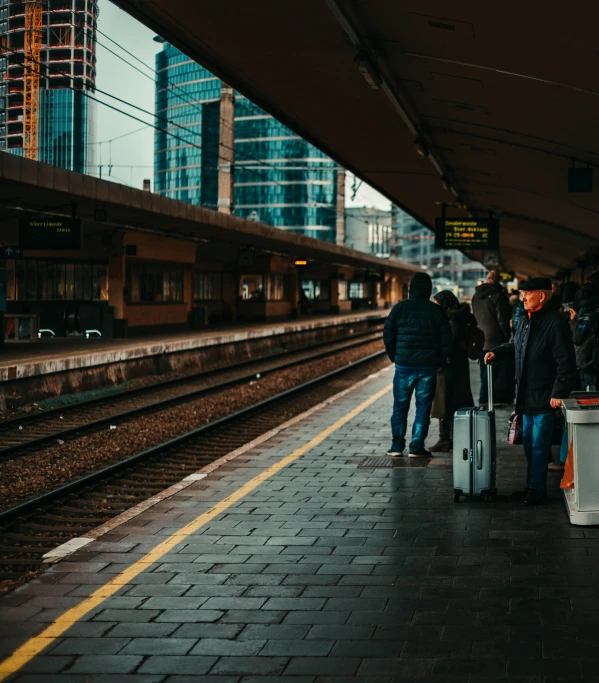 a group of people waiting at a train station, by Kristian Zahrtmann, pexels contest winner, city view, square, luggage, thumbnail