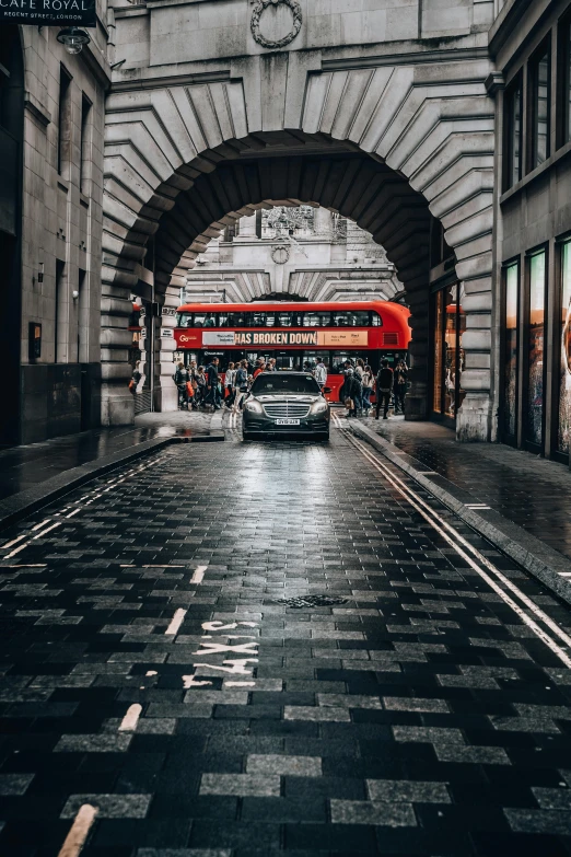 a red double decker bus driving down a wet street, by Austin English, pexels contest winner, giant majestic archways, supercar, gif, square