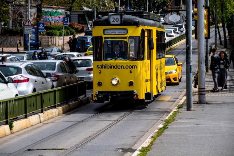 a tram car is driving down the street in front of cars