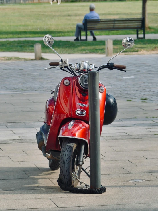 a red scooter parked on the side of a road, in a city square, today\'s featured photograph 4k, shiny silver, colour photograph