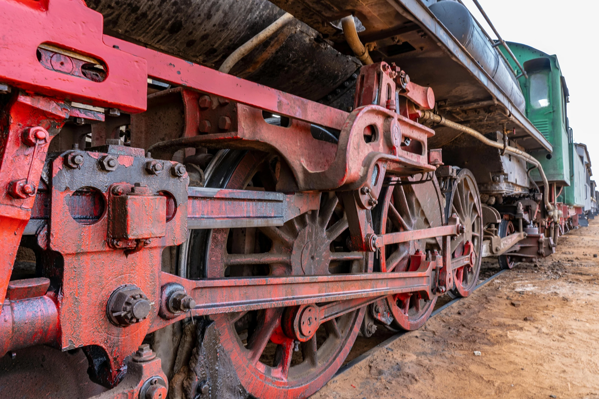 a close up of a train on a track, museum photo, cogs and wheels, dull red flaking paint, thumbnail