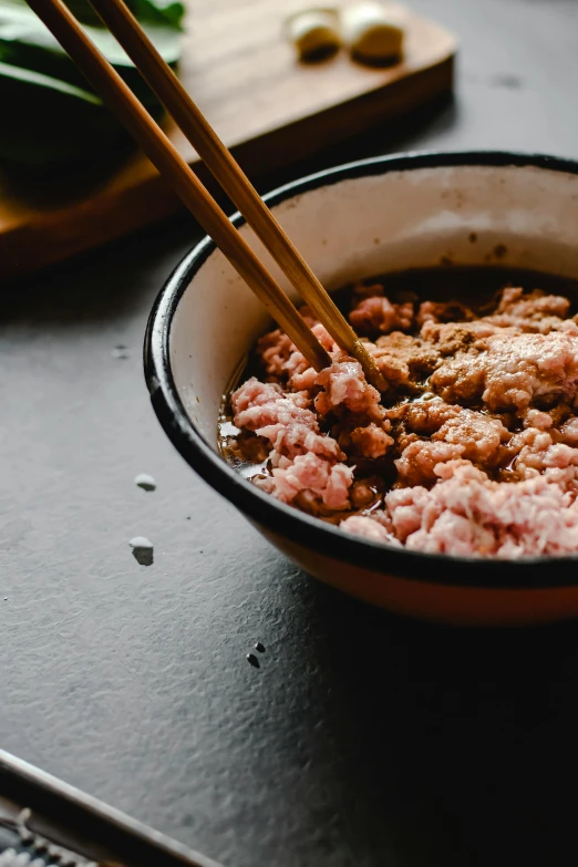 a bowl of food with chopsticks in it, inspired by Tani Bunchō, trending on unsplash, mingei, ground meat, pink slime everywhere, thumbnail, full body close-up shot