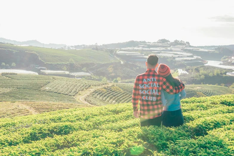 a couple standing on top of a lush green hillside, by Julian Allen, pexels contest winner, wearing farm clothes, social media, 🚿🗝📝