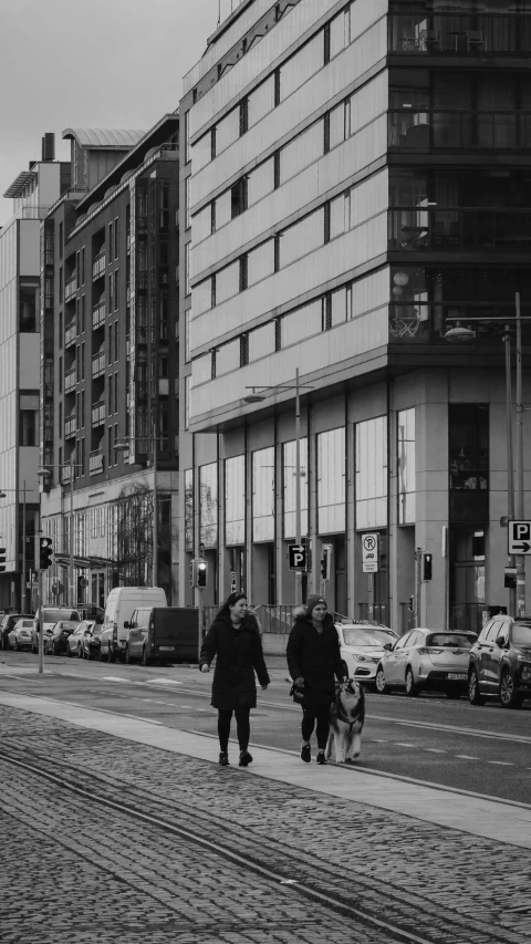 a couple of people that are walking down the street, inspired by Thomas Struth, pexels contest winner, cars and people, warsaw, low quality photo, complex buildings
