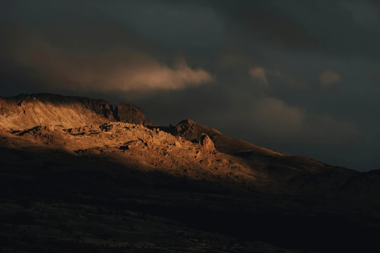 a sunset view of a mountain range under a dark sky