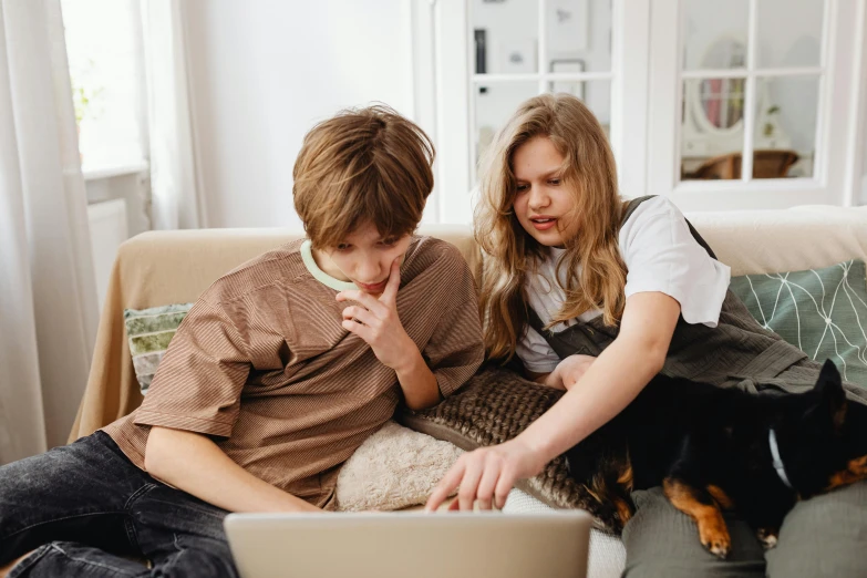 a boy and a girl sitting on a couch looking at a laptop, trending on pexels, aged 13, avatar image, high quality image, eating