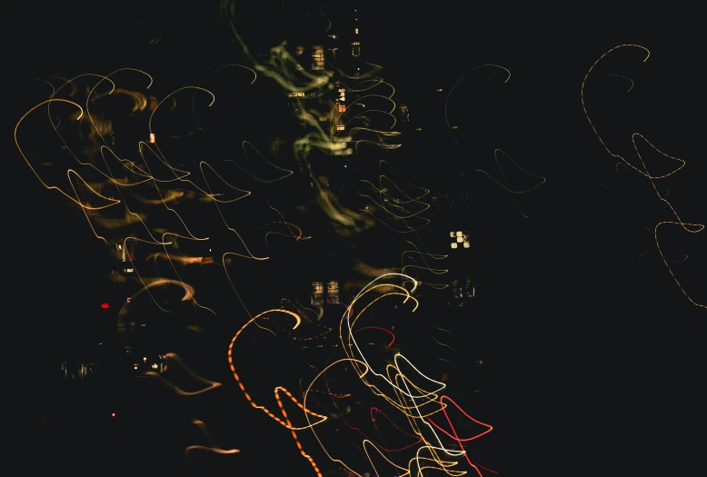 a blurry picture of a city at night, by Carey Morris, pexels, lyrical abstraction, swirls, black and gold wires, high resolution image, vibrant scattered light