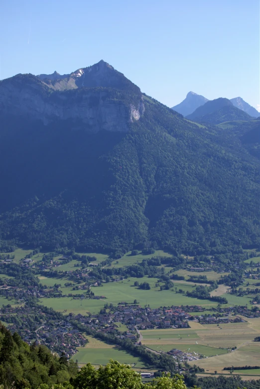 a small village is in the foreground, and an overlook point to the other side of a hill that stretches beyond