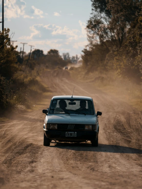 a car traveling down a dirt road in the forest