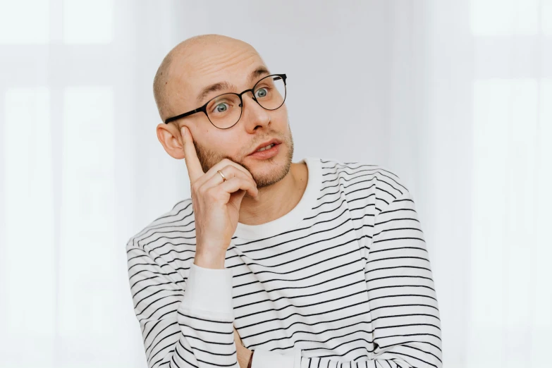 a bald man wearing glasses and a striped shirt, inspired by Leo Leuppi, trending on pexels, thin young male, thoughtful ), anna nikonova aka newmilky, shaven
