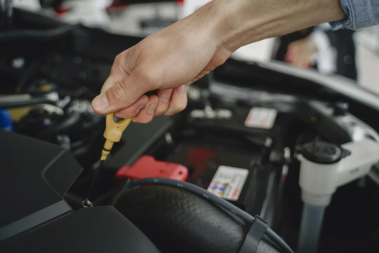 a person holding a key while repairing a car's engine