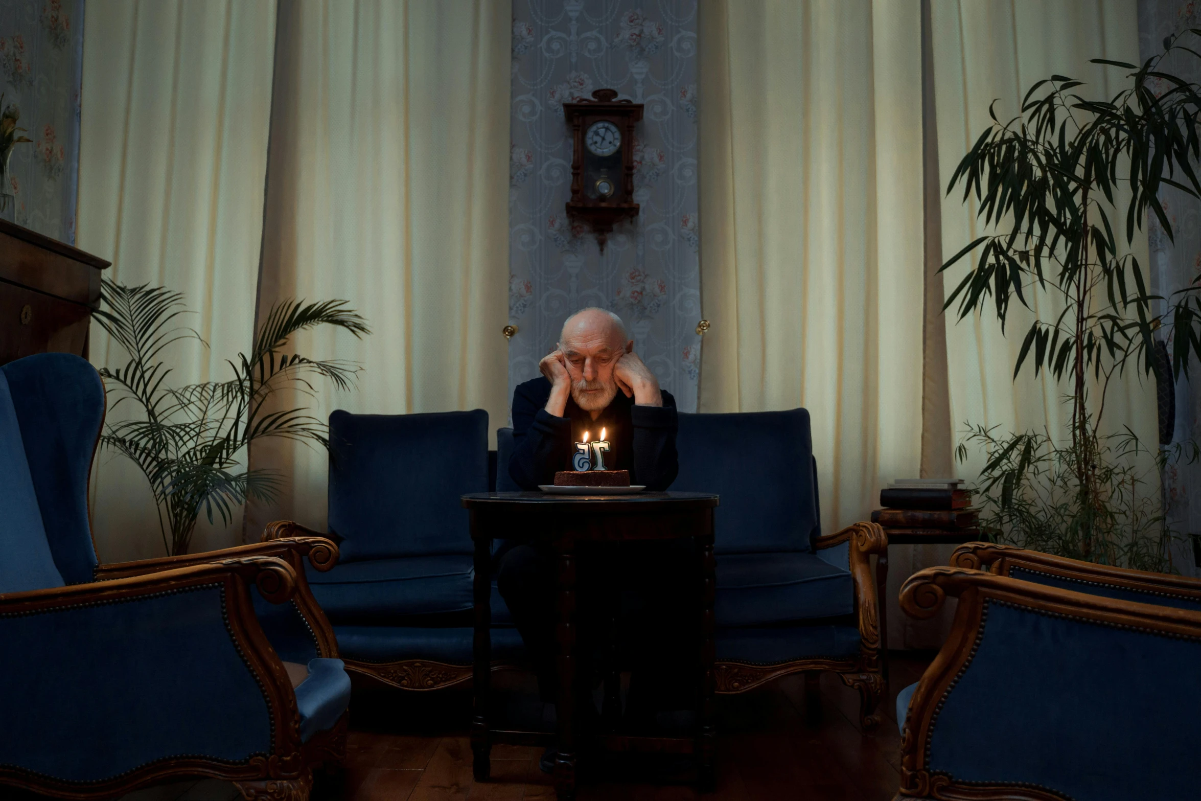 a man sitting at a table with a lit candle in front of him, by Elsa Bleda, hyperrealism, nursing home, stålenhag, blue room, worried