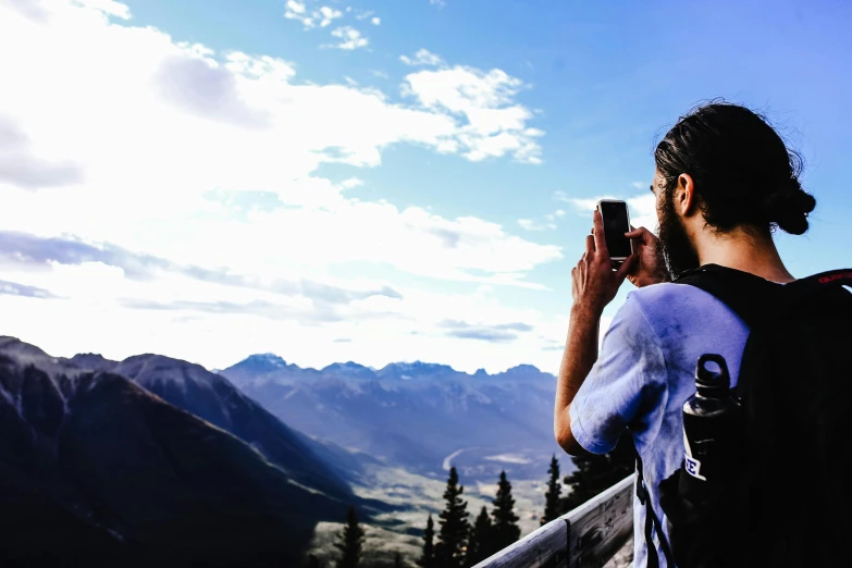 a person taking a pograph while standing at the top of a mountain