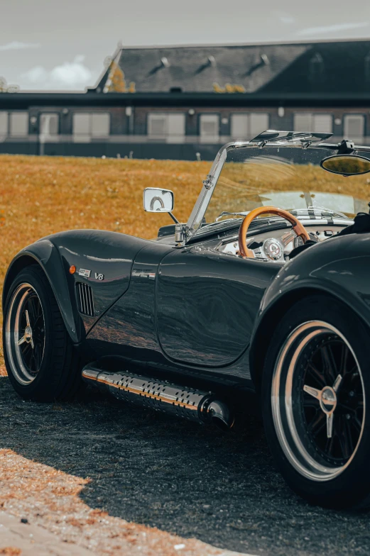 a black classic sports car parked in front of a house