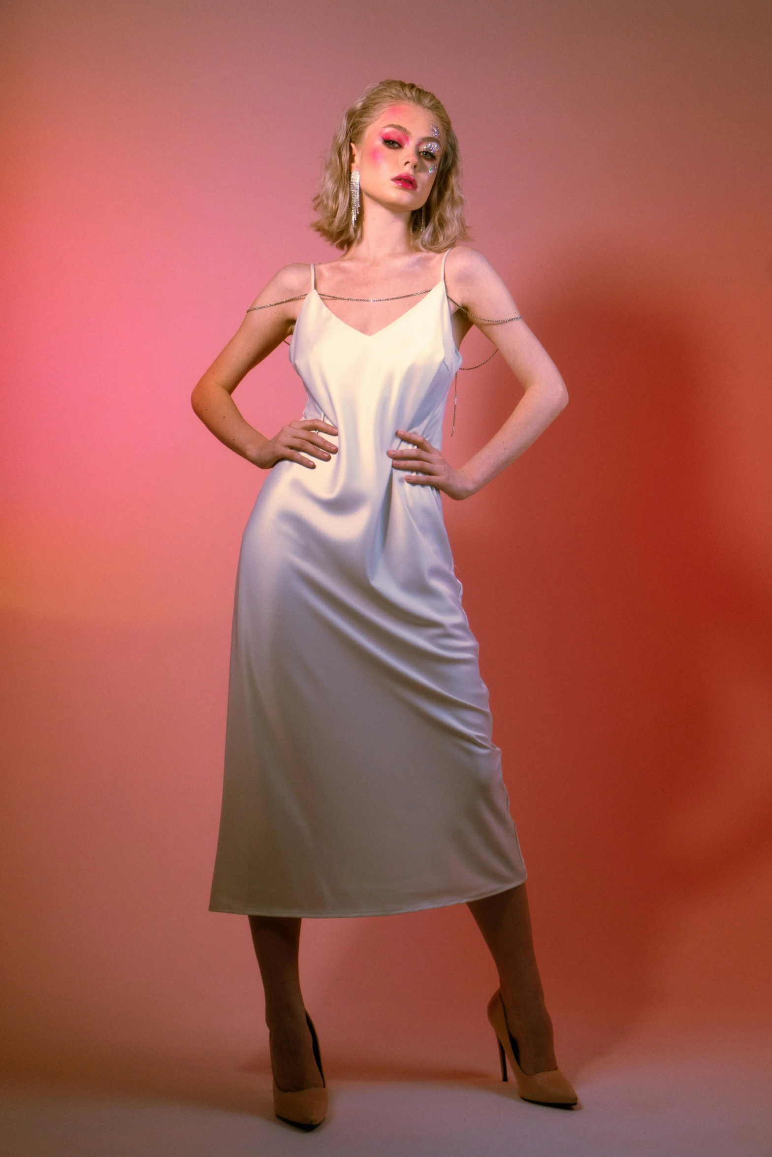 a model poses wearing a silver dress