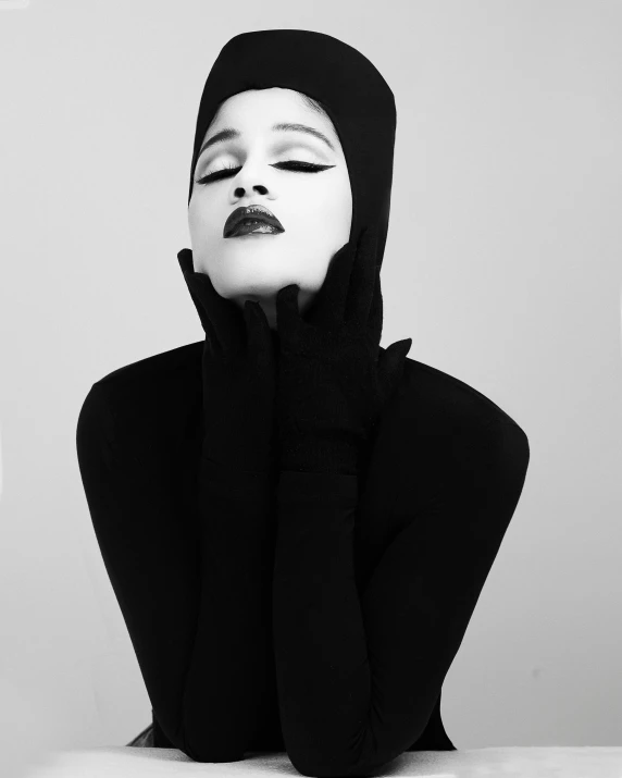 a black and white photo of a woman with makeup, inspired by Herb Ritts, trending on pexels, hurufiyya, white hijab, wearing a black catsuit, zendaya, wearing pointed hoods