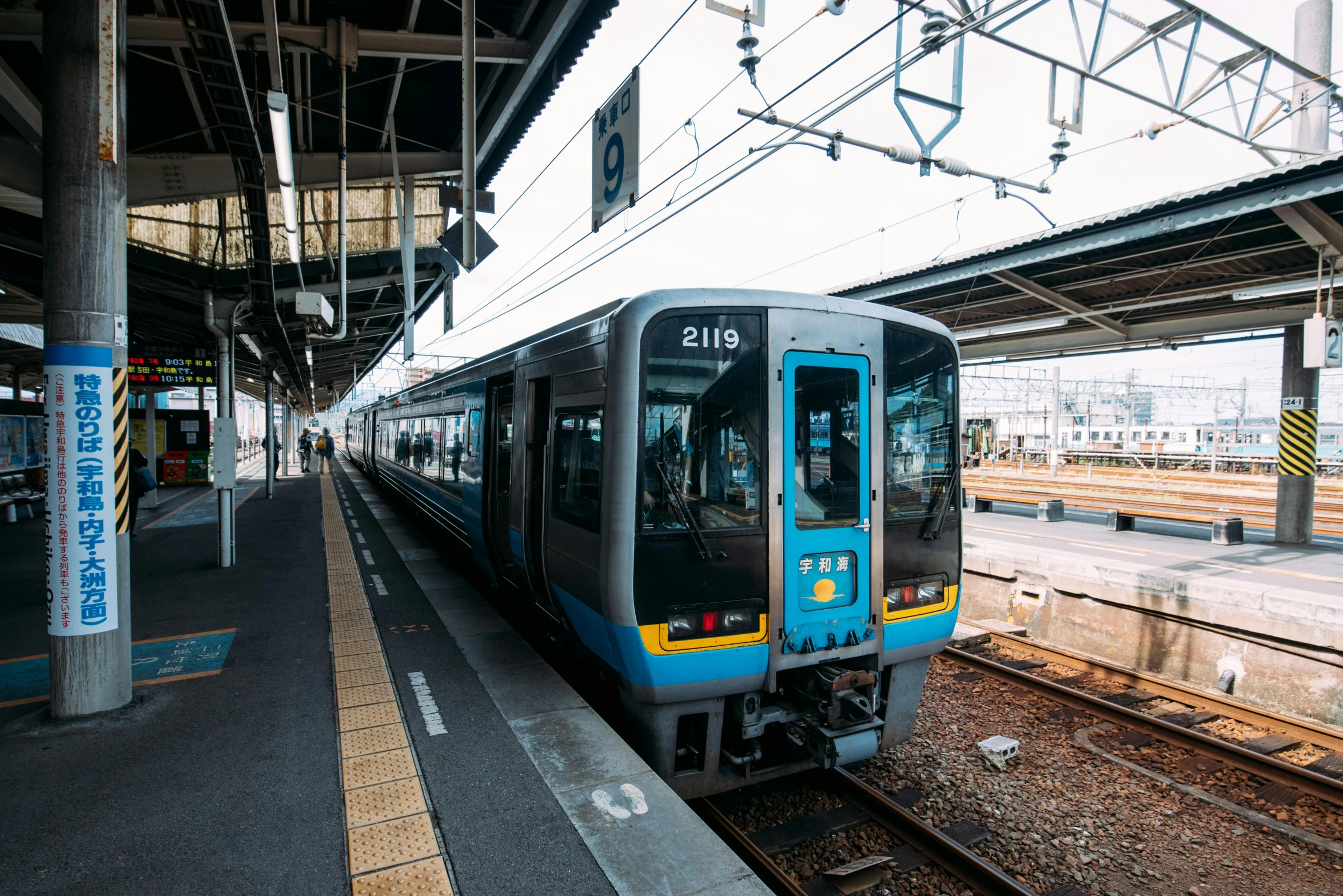 a train pulling into a train station next to a platform, unsplash, sōsaku hanga, blue and grey, square, around 20 yo, 2263539546]