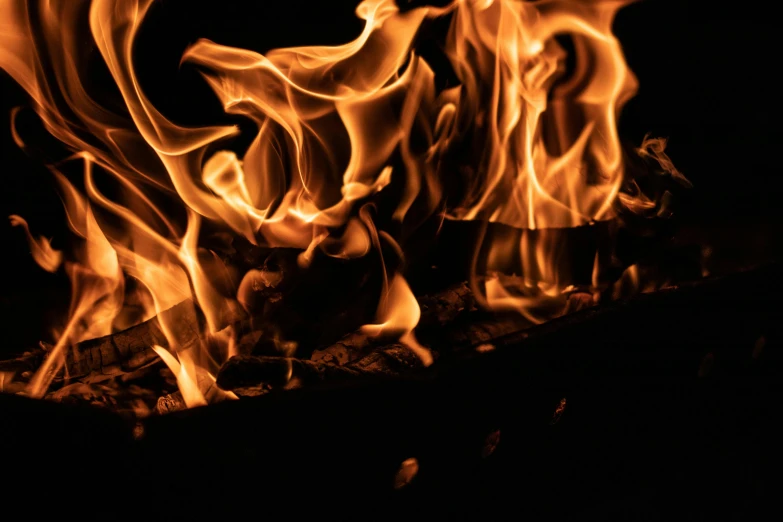 a fire can be seen in the dark, while it looks like it is burning