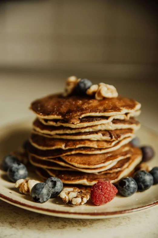 a stack of pancakes sitting on top of a white plate, a portrait, pexels, seeds, dark blue, a wooden, thumbnail