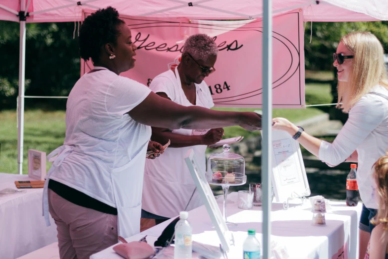 two women handing out samples from a birdcage