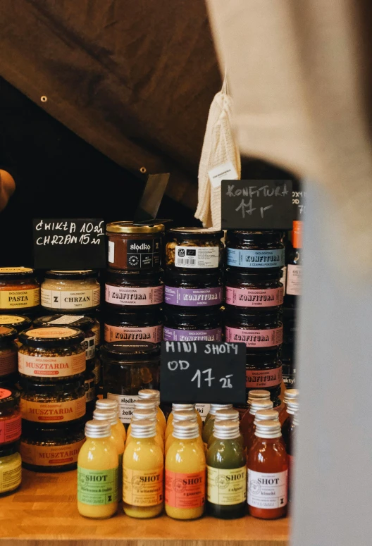 a wooden table topped with jars of food, unsplash, shop front, labels, thumbnail, finely painted