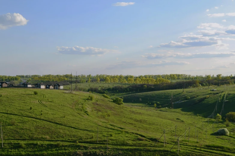 farm buildings along the hillside are seen in the distance